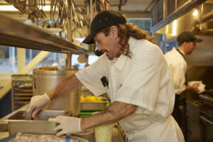 a cook at work in a busy restaurant kitchen